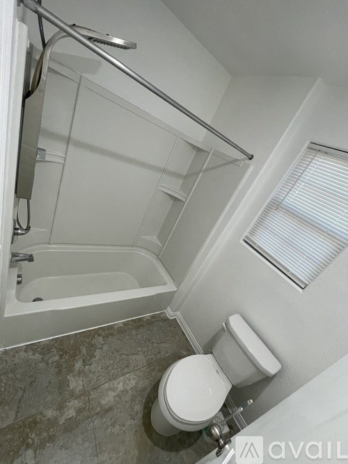 A white toilet is next to a bathtub in a bathroom.