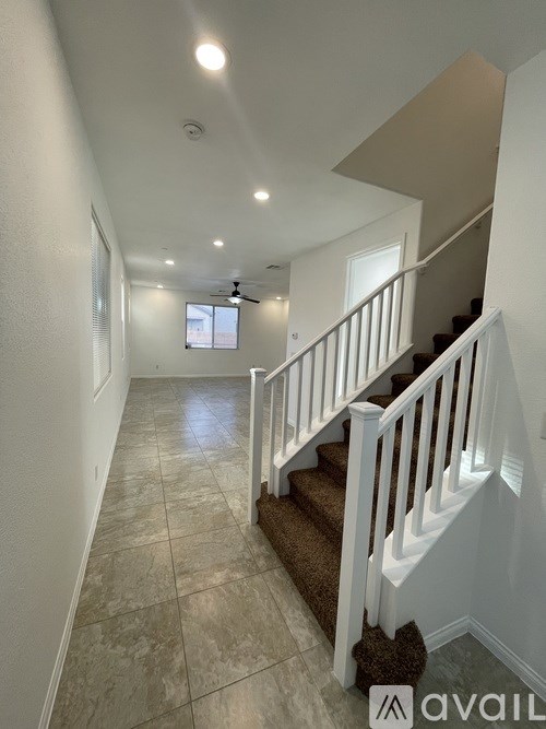 A hallway with a staircase and a window.