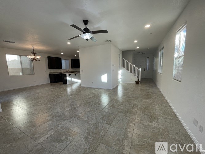 A spacious room with a ceiling fan and marble flooring.