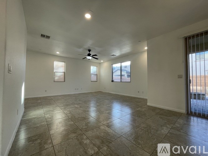 A spacious room with a ceiling fan and tiled flooring.