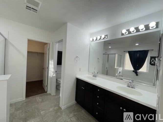 A bathroom with a large mirror and two sinks.