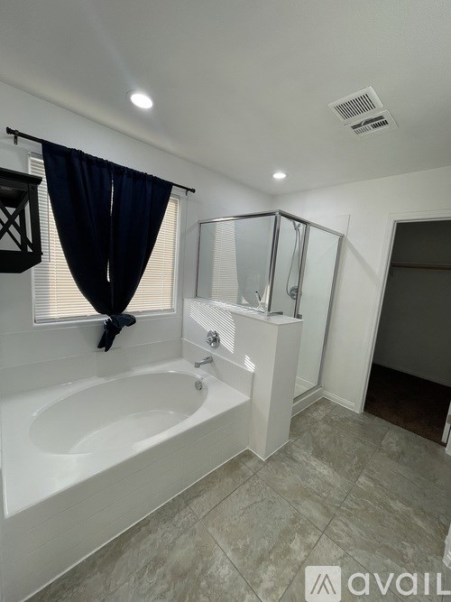 A bathroom with a white bathtub and a walk-in shower.