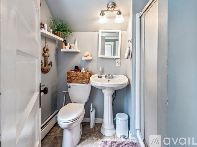 A bathroom with a white toilet, white sink, and a mirror.