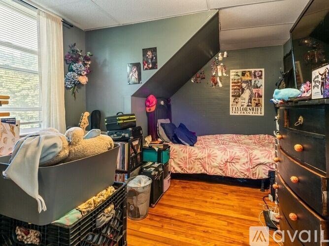A room with a bed, a couch, a shelf, and a window.