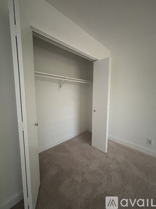 A room with a carpeted floor and a white door.