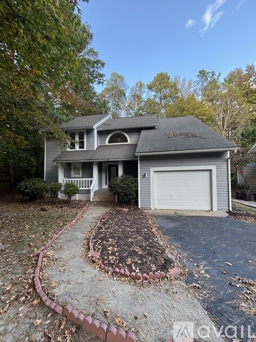 A house with a grey roof and a white garage door.