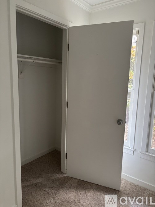 A white door is open to a room with a carpeted floor.