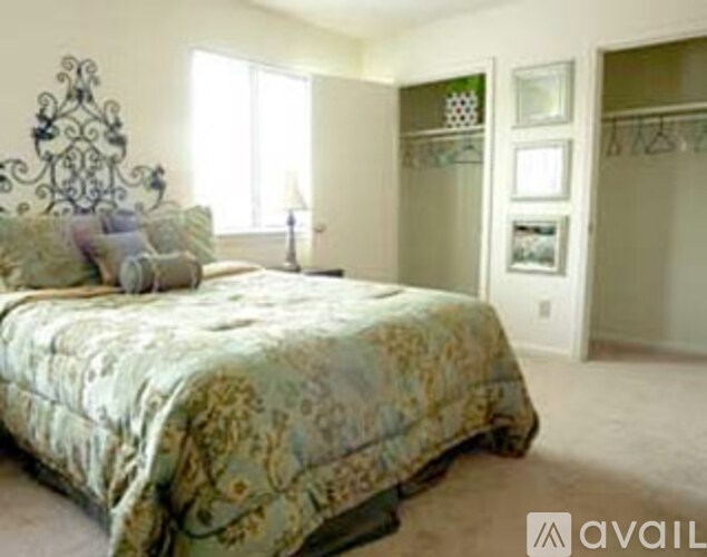 A bedroom with a bed and a wall hanging.