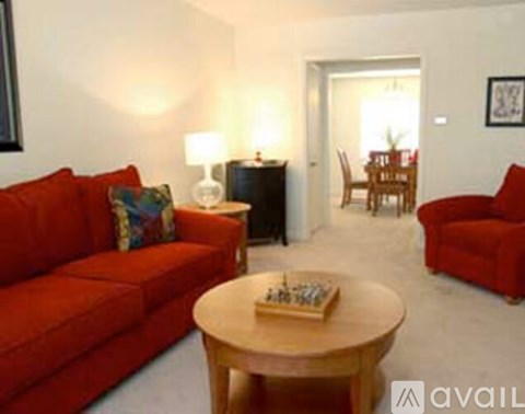 A living room with a red couch and a wooden coffee table.