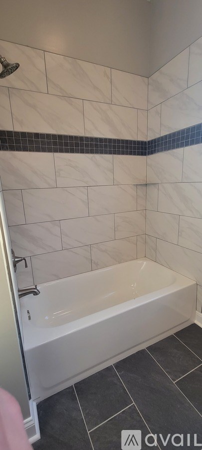 A white tiled shower area with a blue border.