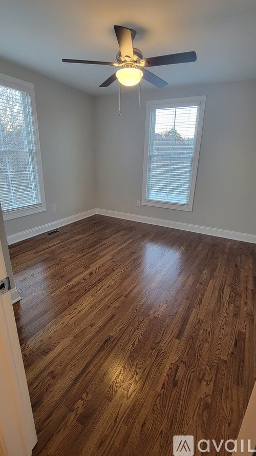 A room with wooden flooring and a ceiling fan.