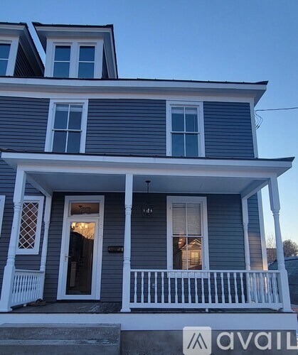 A two-story house with a front porch and a balcony.