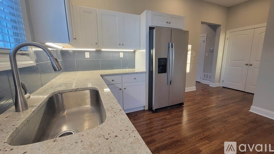 A kitchen with a sink and a refrigerator.