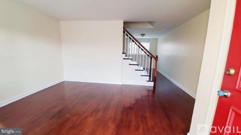 A room with a red door and wooden floors.