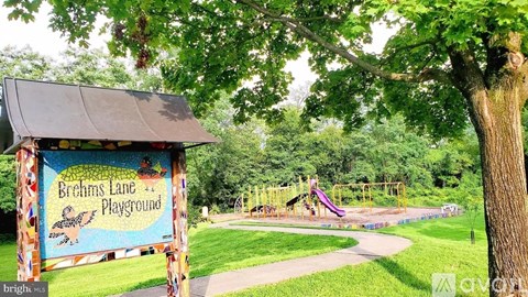A playground named Brehms Lane is surrounded by trees.