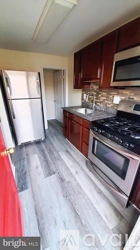 A kitchen with a stainless steel refrigerator and a stainless steel oven.
