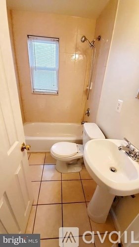 A bathroom with a toilet, sink and shower.