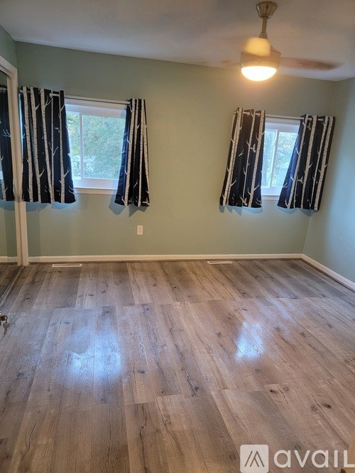 A room with wooden flooring and a ceiling fan.