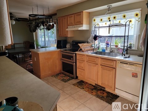 A kitchen with wooden cabinets and a white dishwasher.