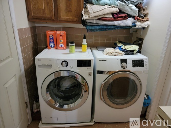 Two front loading washing machines in a small laundry room.