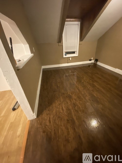A room with wooden flooring and a window.