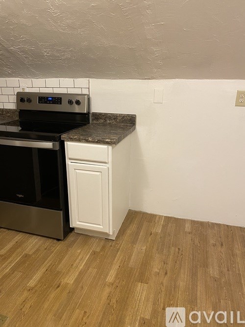 A kitchen with a black oven and white cabinets.