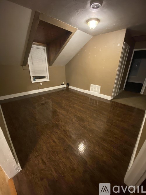 A room with wooden flooring and a skylight.
