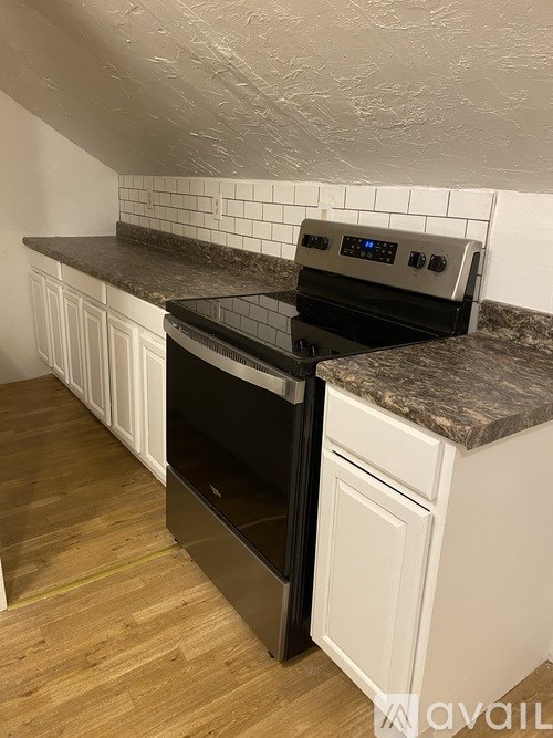 A kitchen with a black oven and white cabinets.