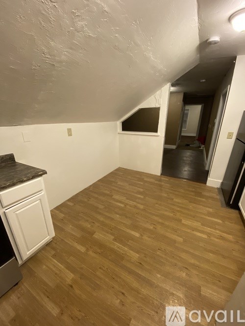 A kitchen with wooden floors and white cabinets.