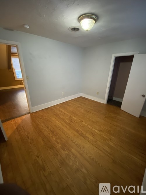 A room with wooden flooring and a light on the ceiling.