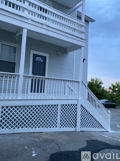 A white house with a lattice fence in front.