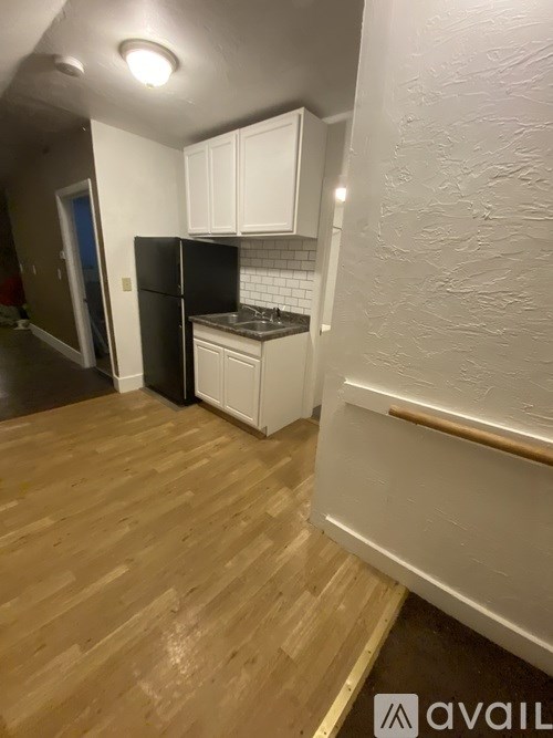 A kitchen with wooden floors and white cabinets.