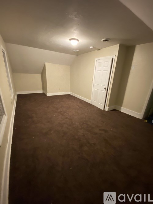 A room with brown carpet and a white door.