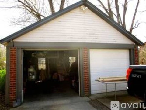 A garage with a white door and a brick pillar.