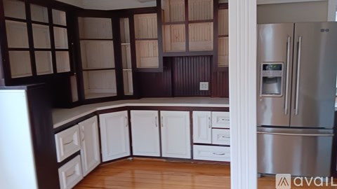 A kitchen with wooden cabinets and a stainless steel refrigerator.