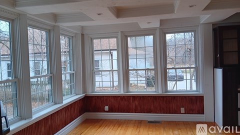 A room with wooden floors and red walls with a large window.