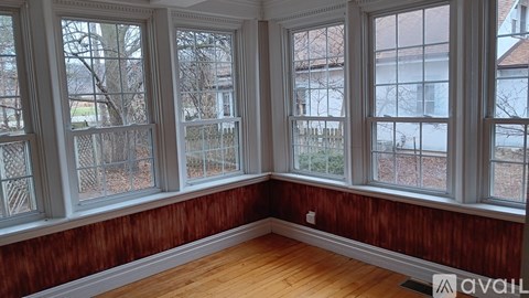 A room with wooden walls and white windows.