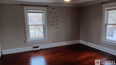A room with two windows and a wooden floor.