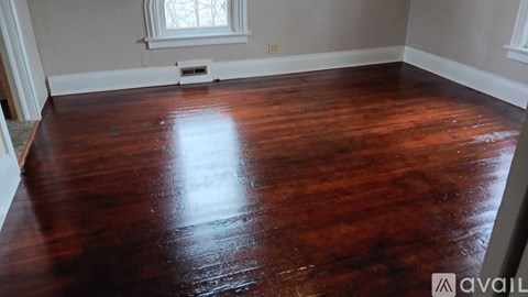 A room with a wooden floor and a window.