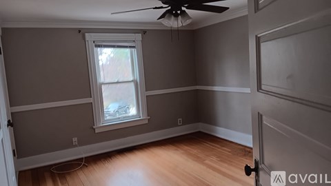 A room with a ceiling fan and a window.