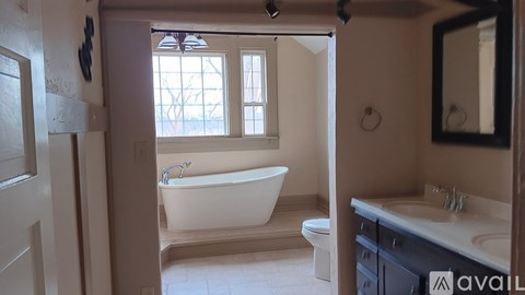 A bathroom with a tub, toilet, and sink.