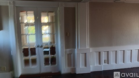 A white door with a glass window is in a room.