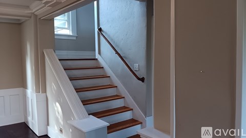 A staircase with white railings and wooden steps.