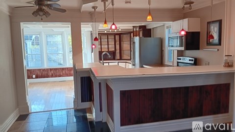 A kitchen with a dark wood grain counter top and a fan on the ceiling.