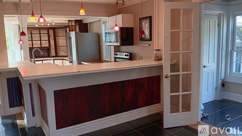A kitchen with a white countertop and a black refrigerator.