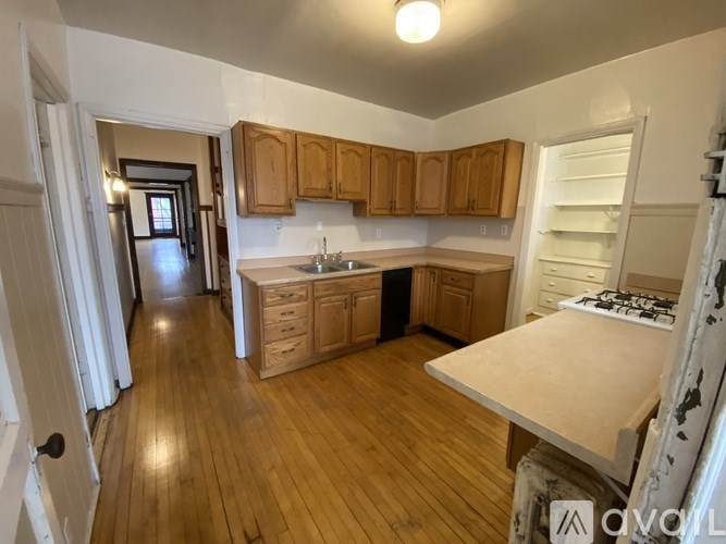 A kitchen with wooden cabinets and a white stove top oven.
