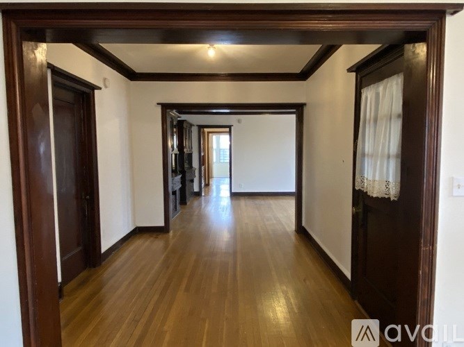 A long hallway with wooden floors and white walls.