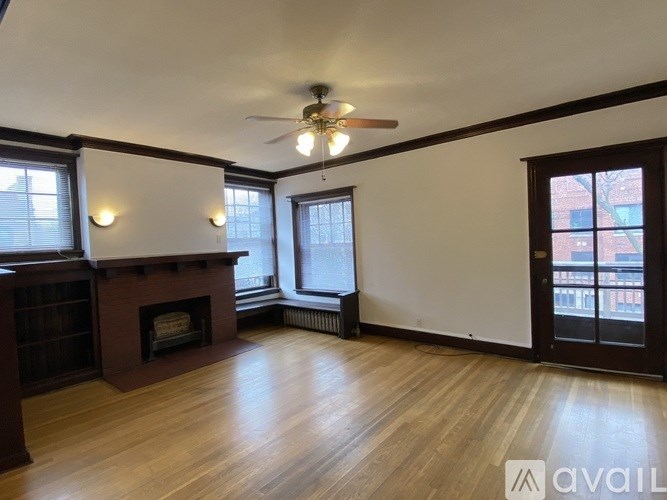 A room with a fireplace and a ceiling fan.