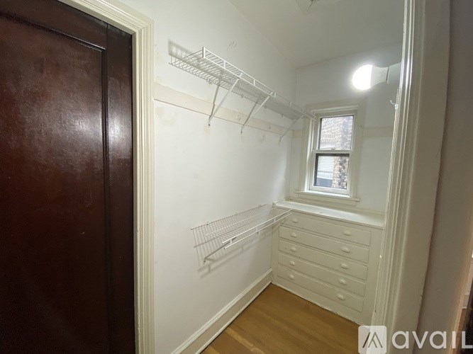 A white wall with a window and a shelf.