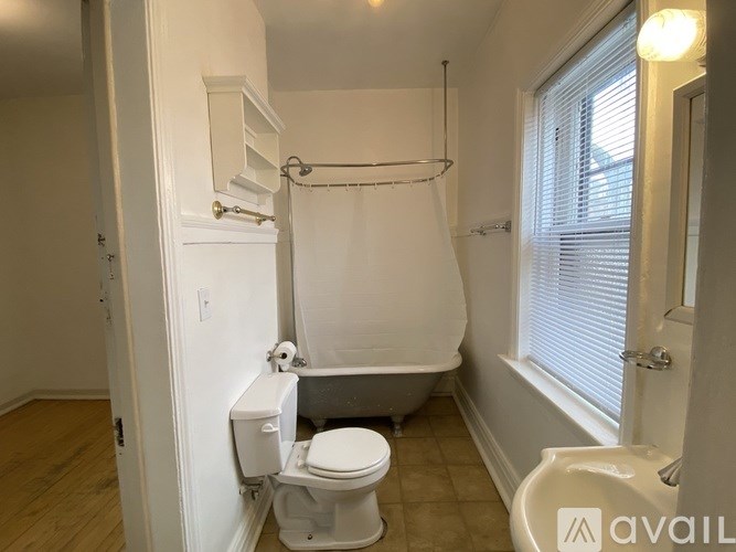 A white bathroom with a toilet, sink, and bathtub.